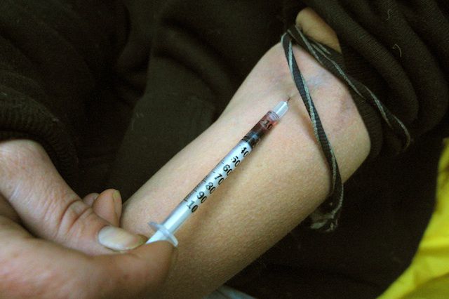 A woman injects heroin below the Manhattan Bridge in November of 2001